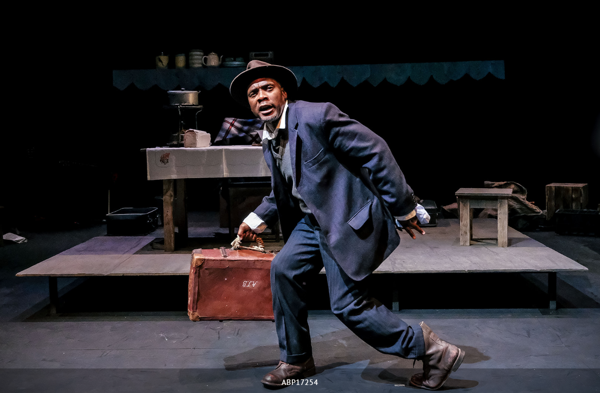‘The Suitcase‘ is one of Mphahlele‘s most popular short stories. This is a cautionary tale about a man who claims a suitcase that was abandoned on a bus. He is confronted by the police, who open the suitcase and make a shocking discovery. ‘The Suitcase‘ first appeared in Drum magazine in 1955. It was adapted into a play by James Ngcobo, and has been performed in South Africa and internationally. Siyabonga Thwala, Masasa Mbangeni, Desmond Dube and John Lata featured in the above performance in Liverpool (U.K.) in 2017. Andrew Billington.